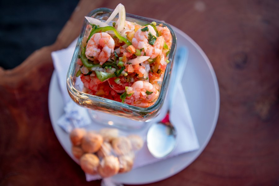 Ceviche de camarón en un vaso de vidrio con tomate y culantro