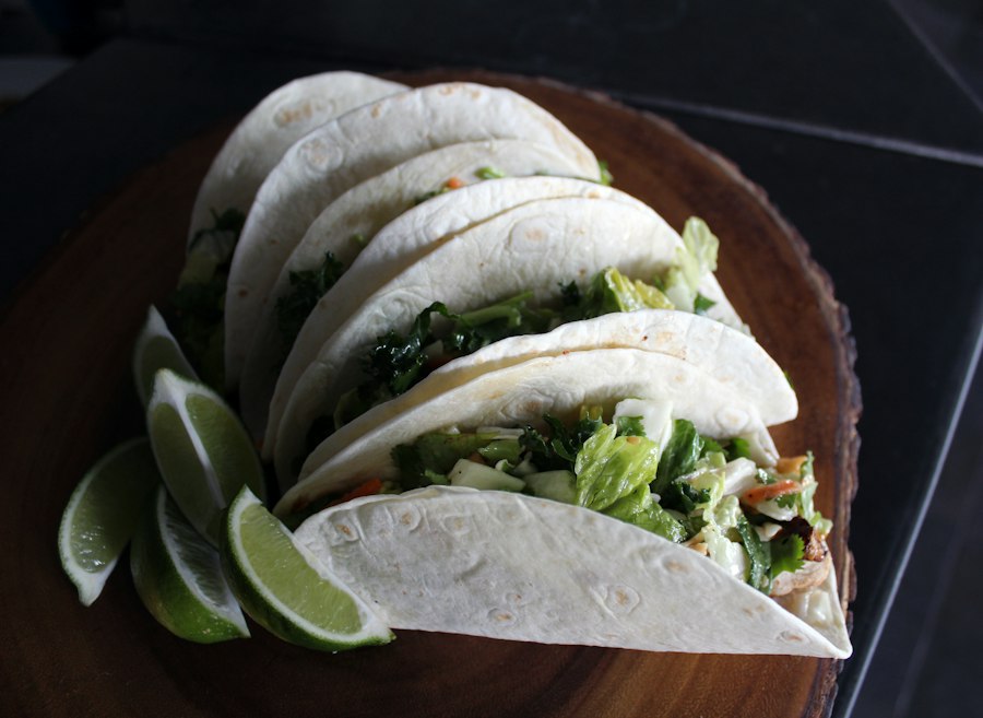 Tacos con repollo y limón sobre una tabla de madera